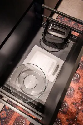 a glass table with a cell phone and a charger at Jacuzzi Cinema Wabi Sabi 3 in Kaunas