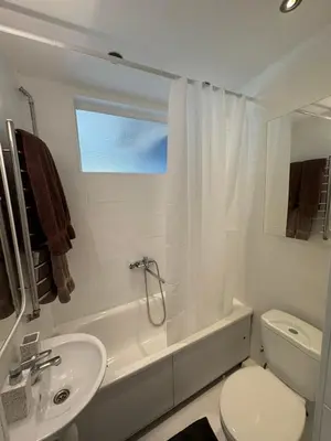 a white bathroom with a sink and a toilet at Central apartament II in Šiauliai