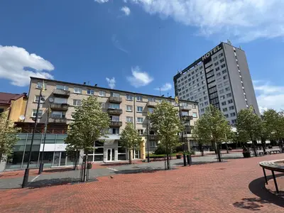 a large building with trees in front of it at Central apartament II in Šiauliai