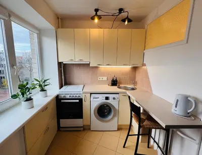 a kitchen with a washing machine and a sink at Central apartament II in Šiauliai