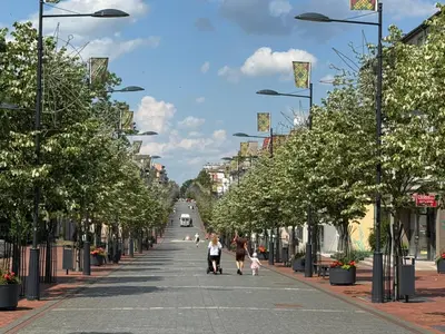 a street with trees and people walking down the street at Central apartament II in Šiauliai
