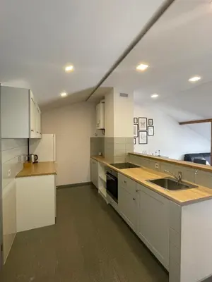 a large kitchen with white cabinets and a sink at newTown 1 in Kaunas