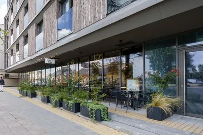 a store front of a building with plants on the sidewalk at Pradoli apartament in Vilnius