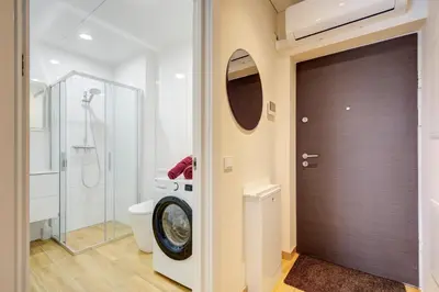 a bathroom with a shower and a toilet and a door at Pradoli apartament in Vilnius