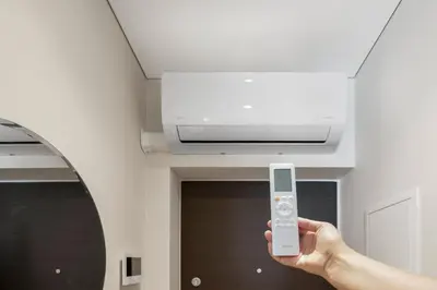 a person holding a remote control in front of a ceiling at Pradoli apartament in Vilnius
