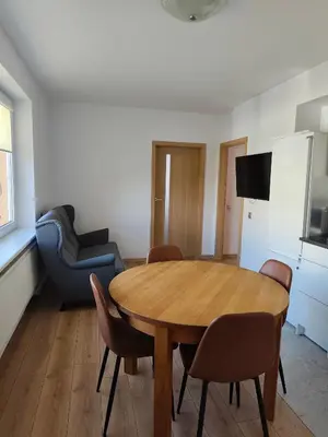 a living room with a wooden table and chairs at CityPark Stay in Šiauliai