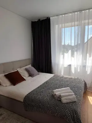 a bedroom with a bed with two towels on it at CityPark Stay in Šiauliai