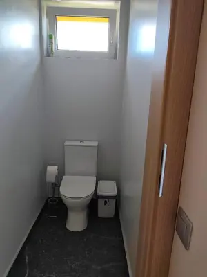 a small bathroom with a toilet and a window at CityPark Stay in Šiauliai