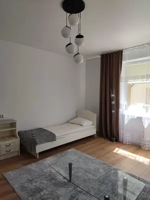a white room with a bed and a window at CityPark Stay in Šiauliai