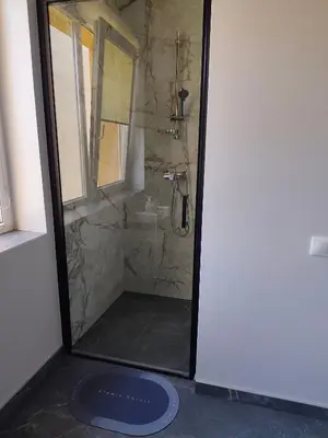 a shower with a glass door in a bathroom at CityPark Stay in Šiauliai