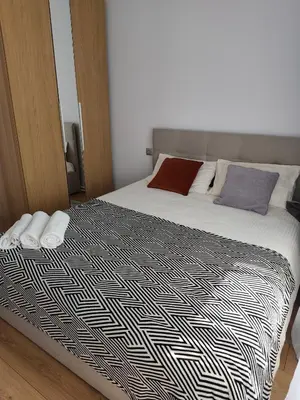 a bedroom with a bed with a black and white comforter at CityPark Stay in Šiauliai