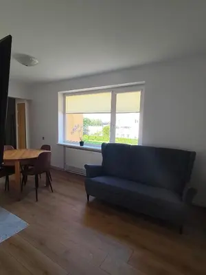 a living room with a blue couch and a table at CityPark Stay in Šiauliai