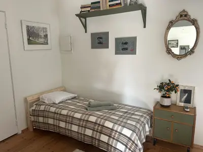 a bedroom with a bed and a mirror on the wall at Saga studio in the center of Pasvalys in Pasvalys