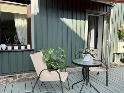 a patio with a table and chairs on a deck at Saga studio in the center of Pasvalys in Pasvalys