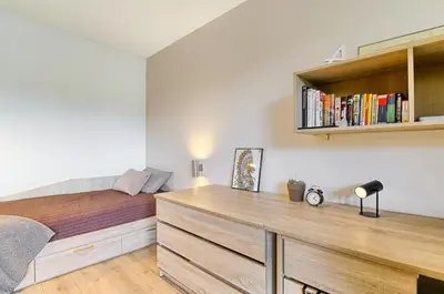 a bedroom with a bed and a desk with books at Spacious 2 Bedroom Apartment in Central Vilnius in Vilnius