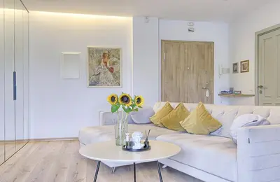 a white living room with a white couch and a table at Spacious 2 Bedroom Apartment in Central Vilnius in Vilnius