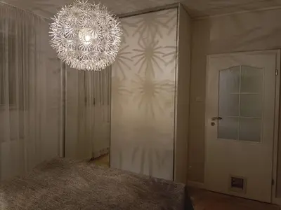 a chandelier in a room with a bed and a door at Kaunas Inn Colors in Kaunas