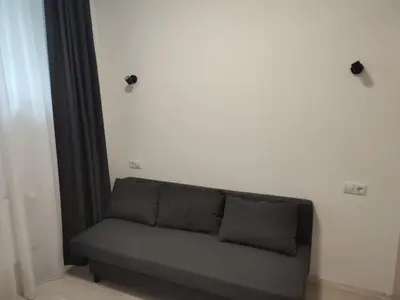 a couch in a room with a white wall at CenterStudioFlat in Vilnius