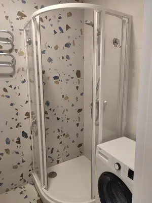 a shower in a bathroom with a washing machine at CenterStudioFlat in Vilnius