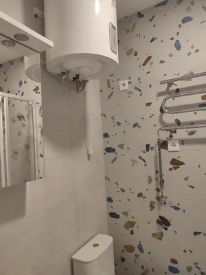 a bathroom with a white toilet and a mirror at CenterStudioFlat in Vilnius