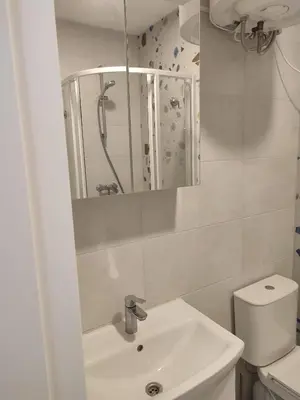 a bathroom with a sink and a toilet and a mirror at CenterStudioFlat in Vilnius