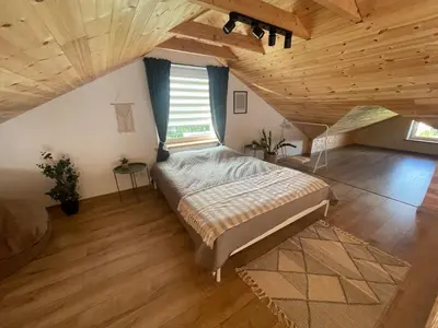 a bedroom with a large bed in a attic at LilHouse loftas Šiauliuose in Šiauliai