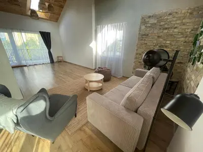 a living room with a couch and a chair at LilHouse loftas Šiauliuose in Šiauliai
