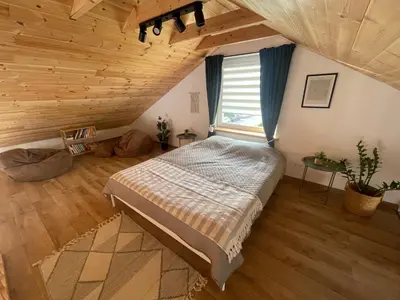 a bedroom with a bed and a wooden ceiling at LilHouse loftas Šiauliuose in Šiauliai