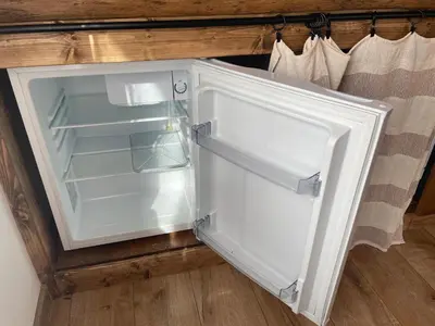 an empty refrigerator with its door open in a kitchen at LilHouse loftas Šiauliuose in Šiauliai