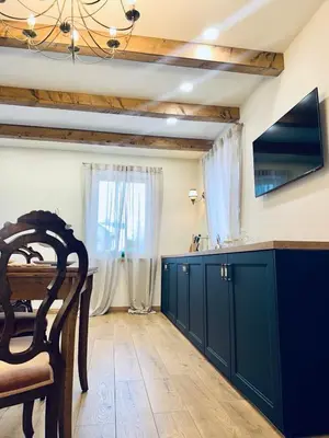 a kitchen with a dark blue cabinets and a television at Jaukus Aleksoto butas Kaune su atskiru įėjimu, šalia Senamiesčio in Kaunas