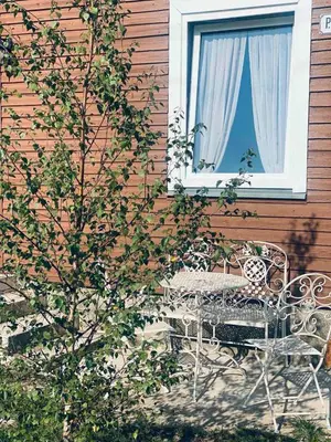 a patio with a table and chairs and a window at Jaukus Aleksoto butas Kaune su atskiru įėjimu, šalia Senamiesčio in Kaunas