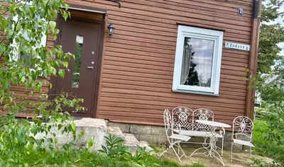 two chairs and a table in front of a house at Jaukus Aleksoto butas Kaune su atskiru įėjimu, šalia Senamiesčio in Kaunas
