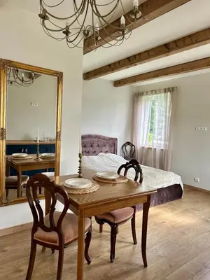 a dining room with a table and a mirror at Jaukus Aleksoto butas Kaune su atskiru įėjimu, šalia Senamiesčio in Kaunas