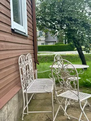 two chairs and a table on the side of a house at Jaukus Aleksoto butas Kaune su atskiru įėjimu, šalia Senamiesčio in Kaunas