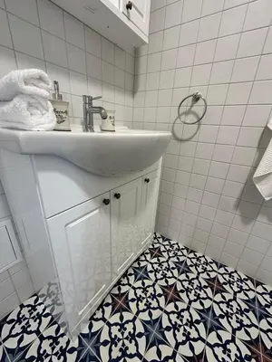 a bathroom with a sink and a tile floor at Jaukus Aleksoto butas Kaune su atskiru įėjimu, šalia Senamiesčio in Kaunas