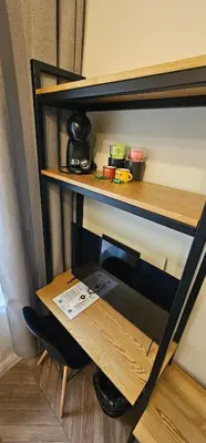 a wooden shelf with a table in a room at Platforma2b one in Šiauliai
