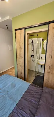a bedroom with a bed and a bathroom with a shower at Platforma2b one in Šiauliai