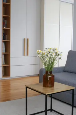 a living room with a coffee table with flowers on it at Šiaulių centre modernus butas 1-4 žmonėms in Šiauliai