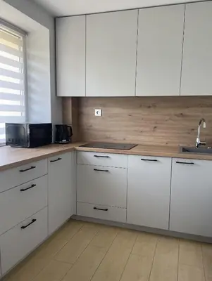a kitchen with white cabinets and a sink at Šiaulių centre modernus butas 1-4 žmonėms in Šiauliai