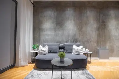 a living room with a blue couch and two tables at NG Charm in Old Town Apt w-Terrace & Netflix in Vilnius