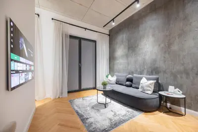 a living room with a couch and a flat screen tv at NG Charm in Old Town Apt w-Terrace & Netflix in Vilnius