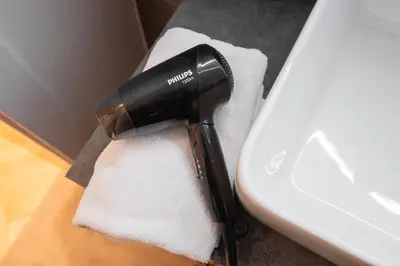 a blow dryer sitting next to a toilet at NG Charm in Old Town Apt w-Terrace & Netflix in Vilnius