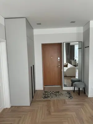 a hallway with a wooden door and a living room at City Centre Apartment with Cathedral View, Self Check-in in Šiauliai
