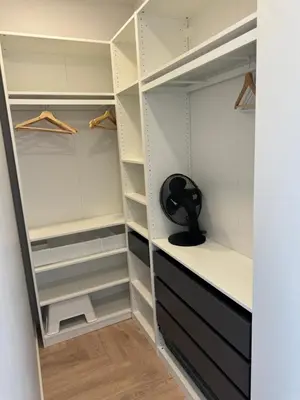 a walk in closet with white and black closets at City Centre Apartment with Cathedral View, Self Check-in in Šiauliai