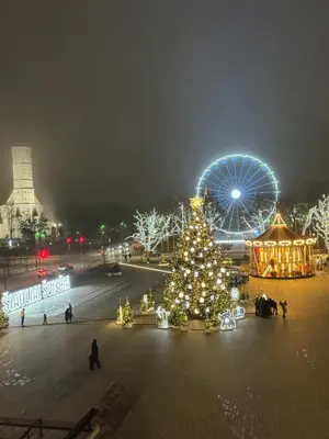 a christmas tree and a ferris wheel at night at City Centre Apartment with Cathedral View, Self Check-in in Šiauliai