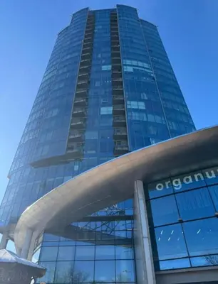 a tall building with glass windows in front of it at Vilnius SkyView 19 in Vilnius