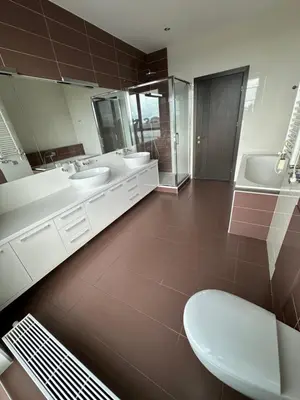 a bathroom with two sinks and two mirrors and a toilet at Vilnius SkyView 19 in Vilnius
