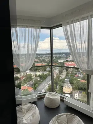 a room with a large window with white curtains at Vilnius SkyView 19 in Vilnius