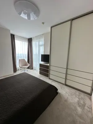 a bedroom with a large bed and sliding glass doors at Vilnius SkyView 19 in Vilnius