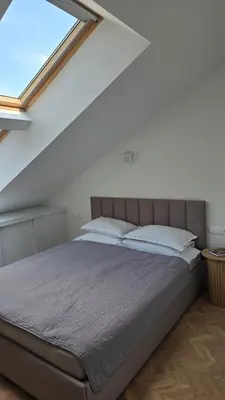 a bedroom with a large bed with a window at Santakos apartmentai in Kaunas